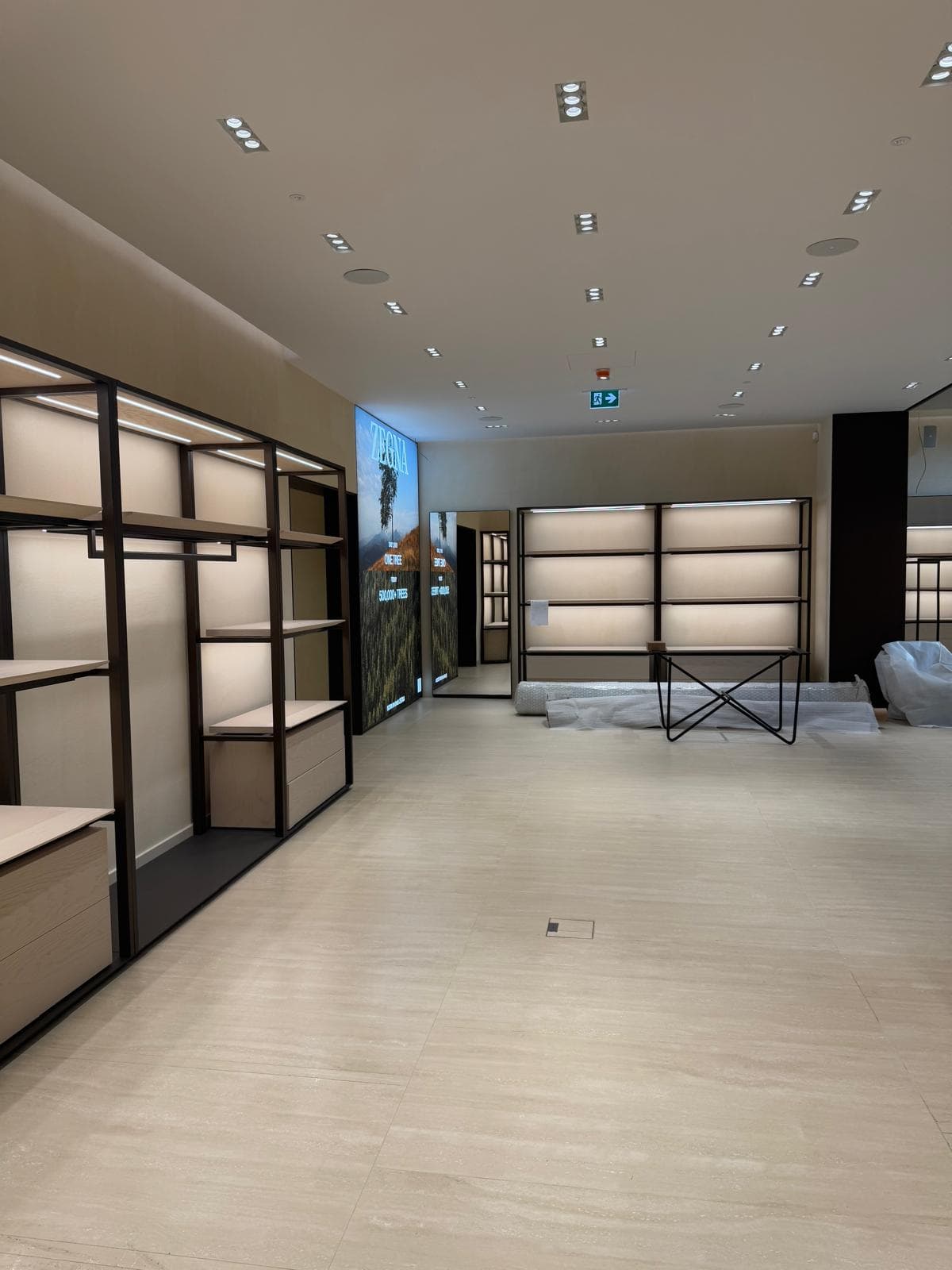 Pulizia fine cantiere boutique Zegna a Parma — interni con scaffalature e pavimento pronti per apertura