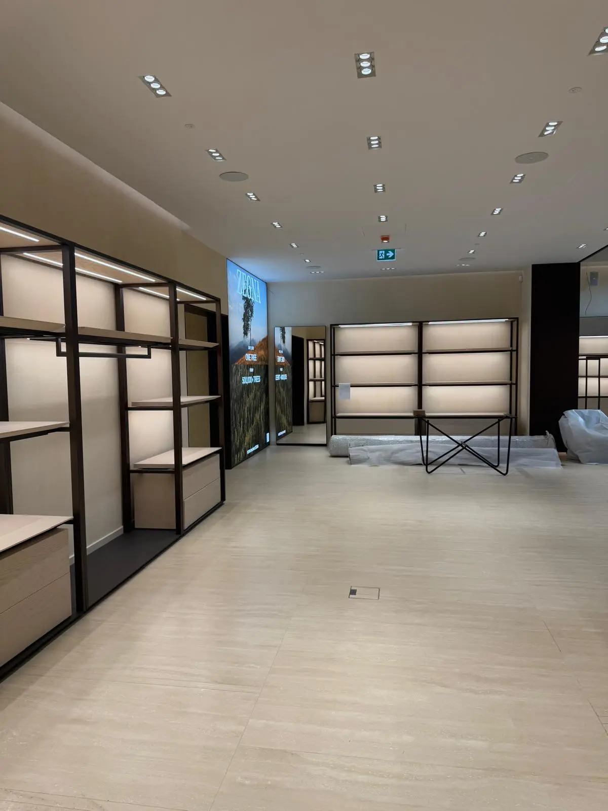 Pulizia fine cantiere boutique Zegna a Parma — interni con scaffalature e pavimento pronti per apertura
