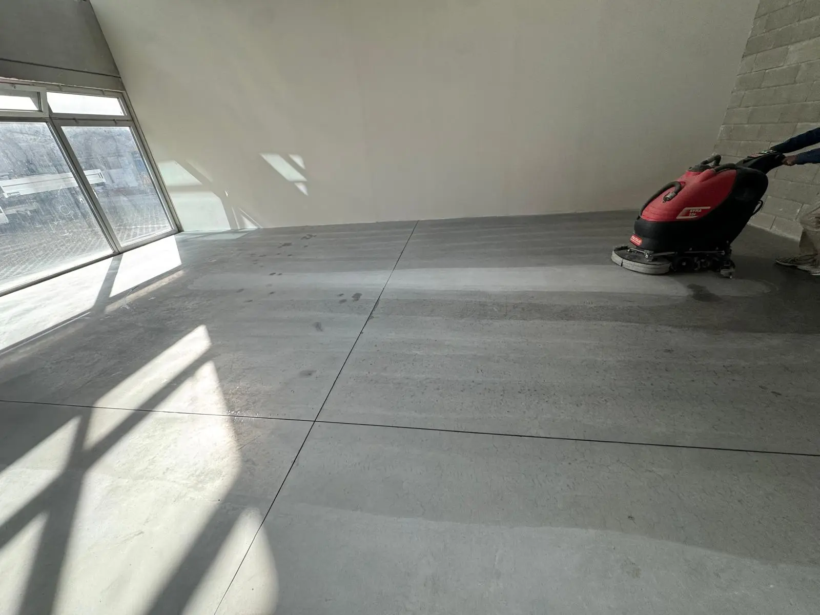 Operazione di lavaggio meccanizzato di una pavimentazione industriale di grande metratura