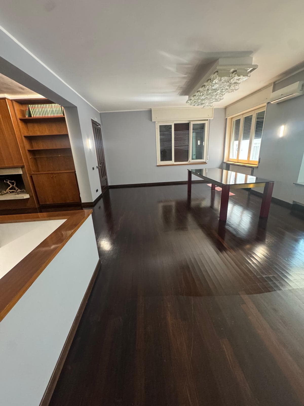 Salone di appartamento elegante con parquet scuro lucidato a specchio e arredi moderni