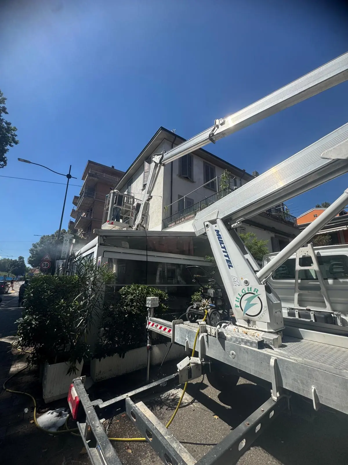 Camion con piattaforma aerea Fulgur Service posizionato per intervento su palazzo residenziale