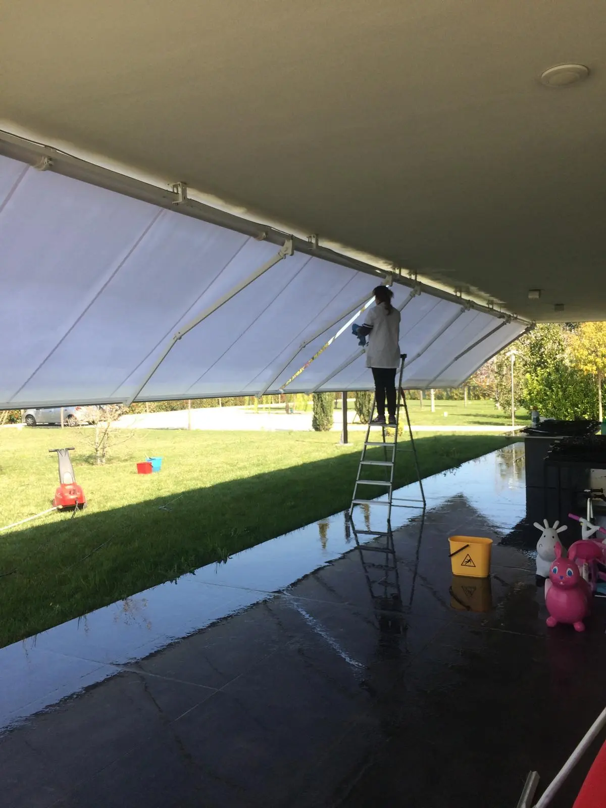 Pulizia interna di una tenda da giardino trasparente con pavimento lucidato a specchio