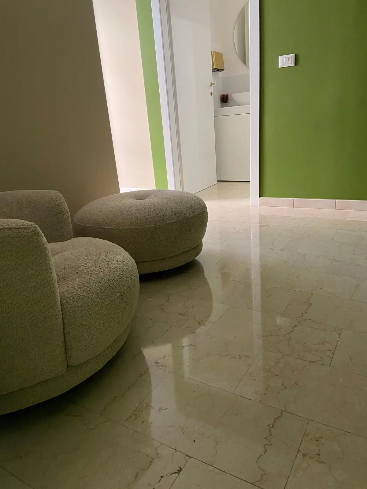 Area attesa di locale commerciale con pavimento in marmo a specchio e sedute moderne