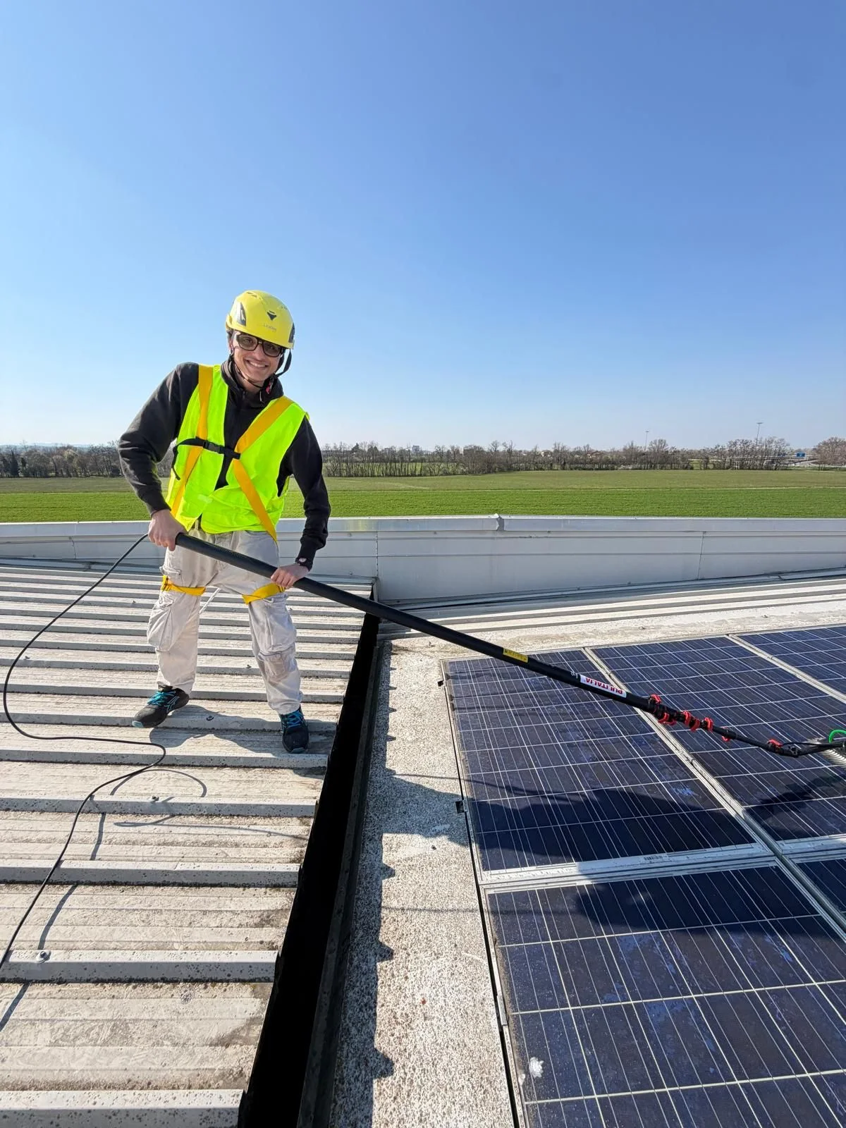 Operatore Fulgur Service al lavoro in copertura durante la pulizia di pannelli fotovoltaici aziendali presso SGIG